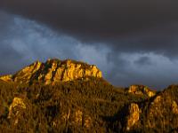Dunkle Abendwolken über sonnenbeschienener Scheibenwand
